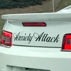 the back end of a white car with an anarchy attack sticker on it