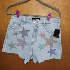 These Sparkling Sequin Star Shorts Are Just Too Cute And Perfect For Summer Festivals And Outings! Unique And Adorable! The Multi-Color Stars Stand Out Even More Against The Light-Denim Background. Minimal Stretch Measurements: Waist Lying Flat - 15in Length - 14in Inseam - 3in Materials: 99% Cotton 1% Spandex Trendy Star Print Jean Shorts For Spring, Trendy Summer Jean Shorts With Star Print, Trendy Jean Shorts With Star Print For Summer, Trendy Jean Shorts With Star Print For Spring, High Waist Jean Shorts With Star Print For Summer, Blue Star Print Shorts, Blue Shorts With Star Print, High Waist Shorts With Star Print For Summer, Summer Denim Shorts With Star Print