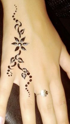 a woman's hand with henna tattoos on it