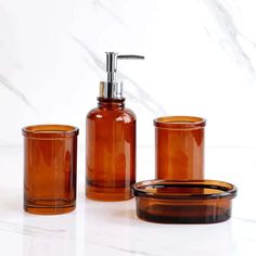 an orange glass bathroom set with soap dispenser and toothbrush holder