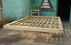 a wooden bed frame sitting in front of a blue wall