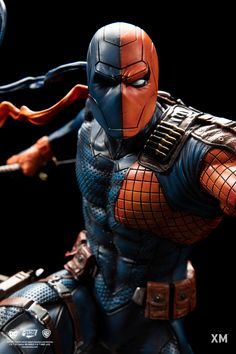 the action figure is being displayed in front of a black background with an orange and blue mask