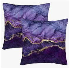 two purple and gold pillows on white background