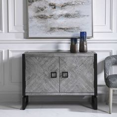 a grey cabinet with two vases sitting on top of it