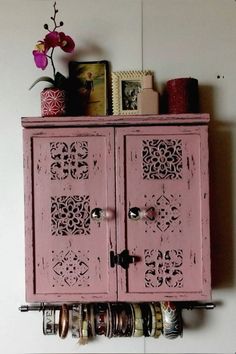 an old pink cabinet is holding jars and knick - knacks on it