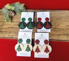 three pairs of plaid and black buffalo print christmas tree earring set on wooden table