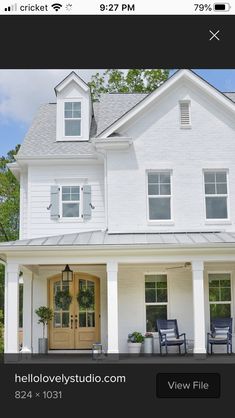 a white house with two chairs on the front porch