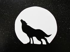 a silhouette of a wolf standing in front of a full moon