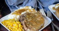 two plates with meat, mashed potatoes, corn and gravy on them