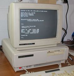 an old computer sitting on top of a wooden desk