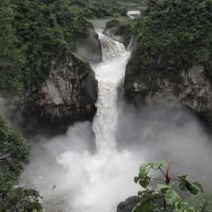 a large waterfall in the middle of a forest