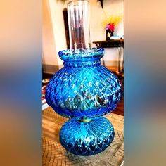 a blue glass vase sitting on top of a table