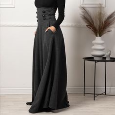 Elevate your winter wardrobe with our High Waisted Wool Maxi Skirt, crafted from luxurious cool wool for a sophisticated touch. This timeless piece features an extra-high waist adorned with stylish buttons, convenient pockets for added functionality, and a floor-length silhouette that effortlessly combines comfort and elegance, making it a versatile addition to any fashion-forward ensemble.  Enjoy the effortless fit and the feminine sense when wearing our creations! Every piece by NikkaPlace is made with lots of love and attention to detail! Cool Wool Machine Wash (40°) Do not tumble dry or bleach Long Skirts With Pockets, Wool Clothing Women, Maxi Wool Skirt, Womens Gothic Fashion, Floor Length Skirts, Stylish Buttons, Wool Clothes, Wool Maxi Skirt, Maxi Skirt With Pockets