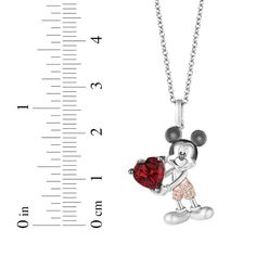 a mickey mouse necklace with a measuring ruler behind it