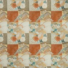 an orange and white patchwork quilt with flowers on the border, all over it