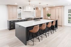 a large kitchen with an island and bar stools