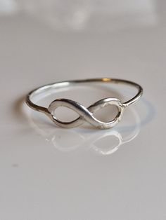 "Introducing our timeless Simple Silver Infinity Ring, designed to symbolize an everlasting bond and endless love. This elegant piece features a delicate infinity symbol, intricately crafted from high-quality 925 sterling silver. The sleek, continuous lines of the infinity loop gracefully embrace the band, creating a harmonious blend of sophistication and minimalism. Its lightweight and comfortable fit make it perfect for everyday wear or special occasions. Show your eternal affection with this Gift Sterling Silver Infinity Stackable Rings, Sterling Silver Infinity Stackable Rings As Gift, Silver Infinity Stackable Rings For Wedding, Sterling Silver Infinity Ring Gift, Sterling Silver Infinity Stackable Rings, Sterling Silver Infinity Ring, Minimalist Sterling Silver Infinity Ring, Silver Infinity Stackable Rings, Adjustable Infinity Stackable Anniversary Rings