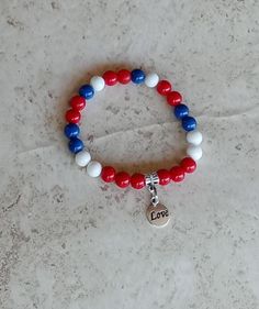 Show your Cuban pride with this beautiful Cuba flag inspired bracelet in blue, red and white colors accentuated by a small love charm in the middle. This stretchy women handmade bracelet is pre-made and ready to ship. Bracelet measures roughly 7.5" and is made with a double strand elastic cord for durability and strength.  Care For best results, keep the bracelet out of water and chemicals. Care instructions would be included in packaging.    Measurement Size 7.5 inches  Materials Antique Tibetan charm and tube bead 8 MM Glass beads Stretch elastic Patriotic Red Beaded Bracelets As Gift, Patriotic Red Friendship Bracelet As Gift, Blue Patriotic Bracelet For Friendship, Patriotic Blue Friendship Bracelets As Gift, White Patriotic Bracelet As Gift, Patriotic Blue Friendship Bracelets, Patriotic White Friendship Bracelets As Gift, Patriotic White Stretch Bracelet As Gift, Patriotic White Friendship Bracelets Gift