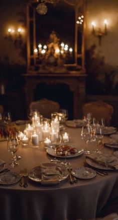 a dining room table is set with candles and plates