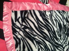 a pink and black blanket with zebra print on it