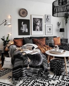 a black and white living room with pictures on the wall, couches, rugs and coffee table