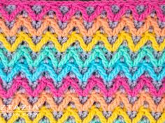 the crocheted blanket is multicolored and has two rows of different colors