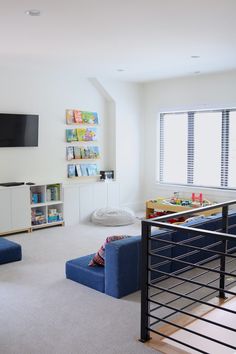 a living room filled with furniture and a flat screen tv mounted to the side of a wall