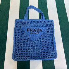 a blue prada bag sitting on top of a green and white striped floor