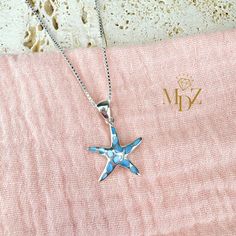 Add a touch of the ocean to your outfit with this stunning Blue Starfish Necklace made with Mother of Pearl. This ocean-inspired beach jewelry piece is perfect for adding a pop of color and whimsy to your summer wardrobe. This starfish necklace is sure to make a statement wherever you go. Bring a piece of the beach with you wherever you wander with this beautiful summer jewelry accessory. ------------------------ Item Details ------------------------ Blue Mother of Pearl Starfish Necklace Pendan Turquoise Starfish Ocean-inspired Jewelry, Light Blue Ocean-inspired Jewelry For Gift, Ocean-inspired Light Blue Jewelry For Gift, Light Blue Ocean-inspired Jewelry Gift, Blue Star Shaped Jewelry For Vacation, Blue Star Jewelry For Vacation, Turquoise Necklace With Starfish Charm, Turquoise Ocean-inspired Necklace With Starfish Charm, Ocean-inspired Turquoise Necklace With Starfish Charm