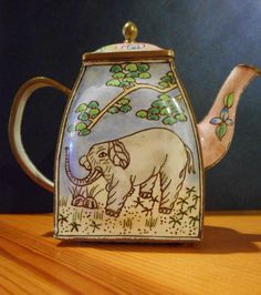 an elephant teapot sitting on top of a wooden table