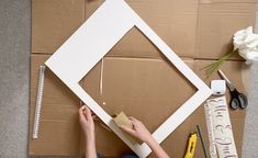 a person is making a frame out of cardboard