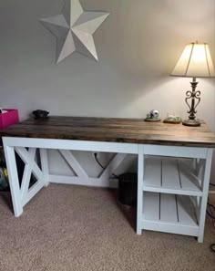 a white desk with a wooden top and shelf underneath it, next to a lamp