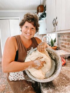 a woman is kneading dough into a bowl