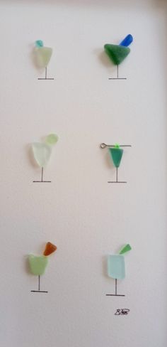 several different colored glass birds mounted to a wall