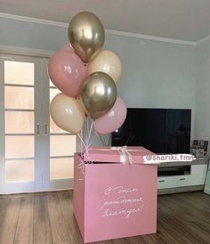 a pink box with some balloons in it and a sign that says, i mean someone deserves champagne