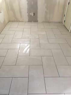 a white tiled floor in a room under construction