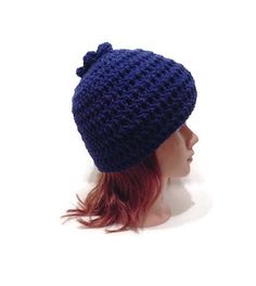 a mannequin head wearing a blue crocheted hat with a bow on it