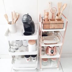 an organized kitchen shelf with utensils, coffee cups and other items on it