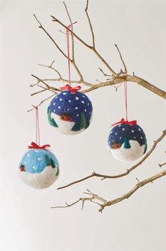 three ornaments hanging from a tree branch