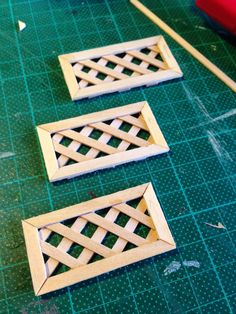 three pieces of wood sitting on top of a green table next to a pair of scissors