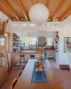 a large wooden table in a kitchen with lots of counter space and decor on the walls