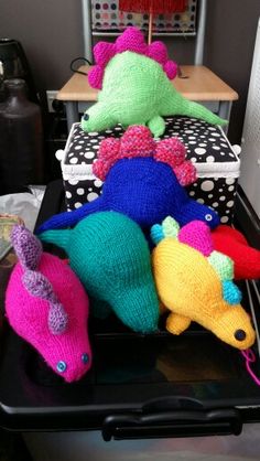 several knitted stuffed animals sitting on top of a black tray