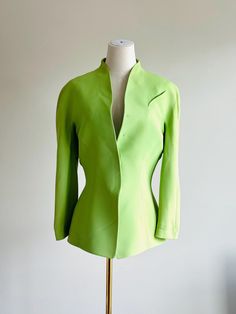 Vintage Thierry Mugler Snap-Front Blazer - Size 40 Very Brat ;) This striking vintage Thierry Mugler blazer in a vibrant green hue embodies the brand's iconic sculptural tailoring. Crafted from a luxurious blend of 53% acetate and 47% viscose, this blazer offers a structured yet soft fit. The unique design features sharp, clean lines with a flattering silhouette, characteristic of Mugler's futuristic aesthetic. The snap-front closure adds a sleek, modern touch to this timeless piece. *Brand: Thi Elegant Green Evening Blazer, Elegant Fitted Green Blazer, Tailored Green Evening Blazer, Tailored Green Blazer For Evening, Green Notch Lapel Blazer For Evening, Structured Long Sleeve Party Blazer, Structured Long Sleeve Blazer For Party, Fitted Green Blazer For Fall, Green Fitted Blazer For Fall