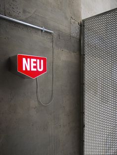 a red neu sign mounted to the side of a wall