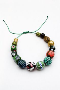 Brighten up your day with this wooden green goddess necklace. It's chunky, funky and colorful so it's a real statement piece. This one is a combination of different shades of green, mustard yellow, white and gold plus heaps of different-sized polka dots, stripes and floral motives. The size of the beads goes from 13 mm to 30 mm. The cord is waxed polyester. It's flexible yet durable. The sliding knot will enable you to adjust the length in no time. The maximum length is 70 cm or 27 inches. Pleas Unique Green Necklaces With Wooden Beads, Artsy Adjustable Green Necklaces, Artsy Green Adjustable Necklaces, Artsy Green Necklaces For Jewelry Making, Bold Handmade Green Jewelry, Green Wooden Beads Jewelry Gift, Green Wooden Beads Jewelry For Gift, Green Wooden Beaded Necklaces, Unique Green Wooden Beaded Necklaces