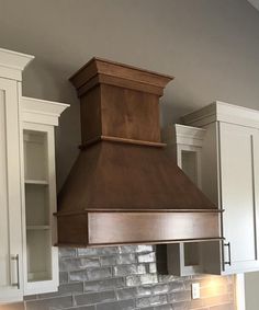 a stove top oven sitting inside of a kitchen next to white cabinets and cupboards