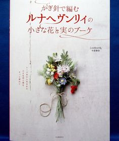 a bouquet of flowers is tied to the side of a wall with japanese writing on it