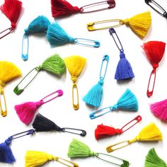 many different colored tassels are arranged on a white surface with metal clips in the middle