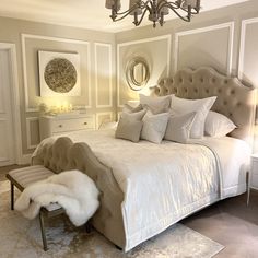 a bedroom with a bed, chandelier and rugs on the floor in front of it