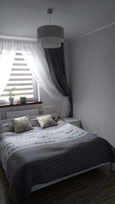 a bed sitting under a window in a bedroom